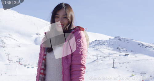 Image of Carefree young woman in snowy ski resort