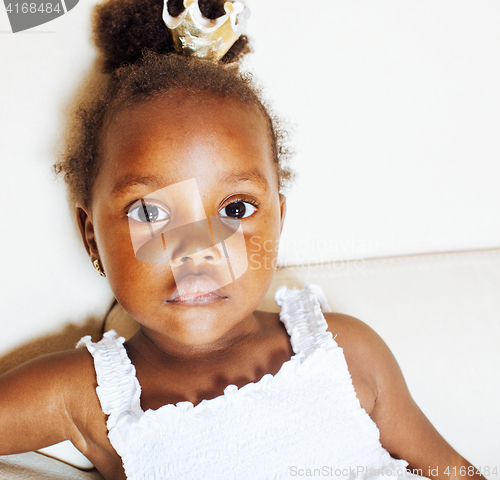 Image of little pretty african american girl sitting in white chair weari