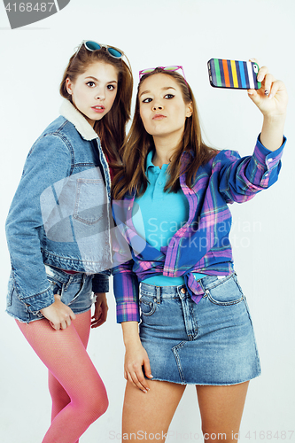 Image of lifestyle people concept: two pretty stylish modern hipster teen girl having fun together, happy smiling making selfie