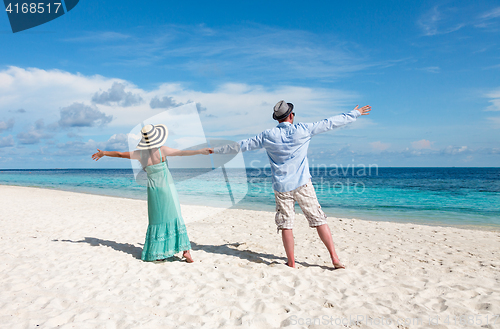 Image of Vacation Couple walking on tropical beach Maldives.