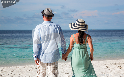 Image of Vacation Couple walking on tropical beach Maldives.