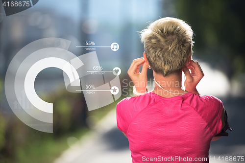 Image of Young fit woman listening music