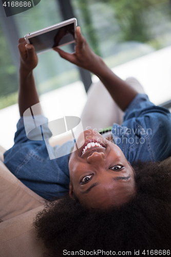 Image of african american woman at home with digital tablet