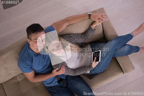 Image of youg couple in living room with tablet top view