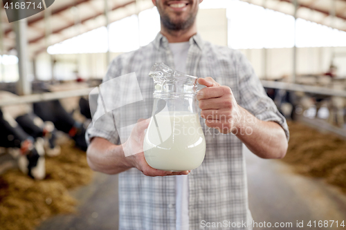 Image of man or farmer with cows milk on dairy farm