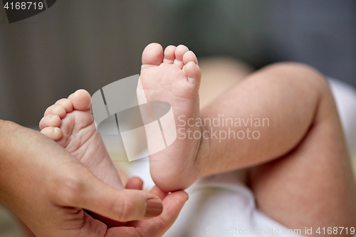 Image of close up of newborn baby feet in mother hands