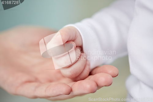 Image of close up of mother and newborn baby hands