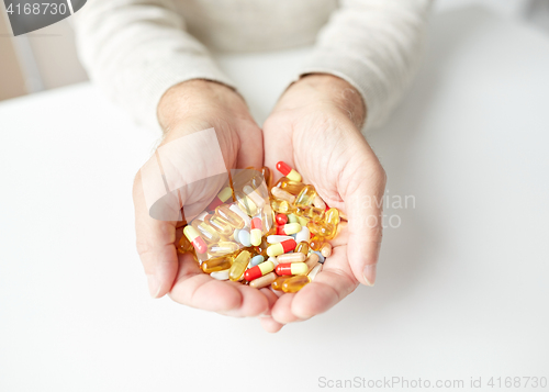 Image of close up of old man hands holding medicine