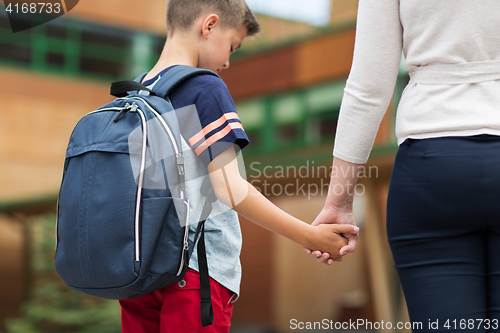 Image of elementary student boy with mother at school yard