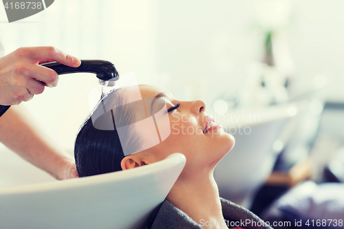 Image of happy young woman at hair salon