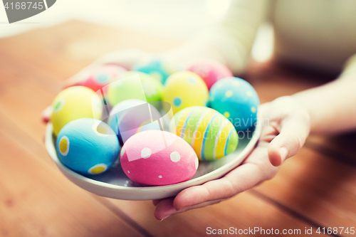 Image of close up of woman hands with colored easter eggs