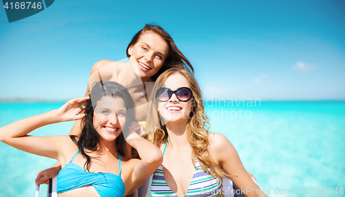 Image of happy young women in bikinis on summer beach