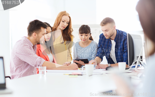 Image of creative team with papers an tablet pc at office