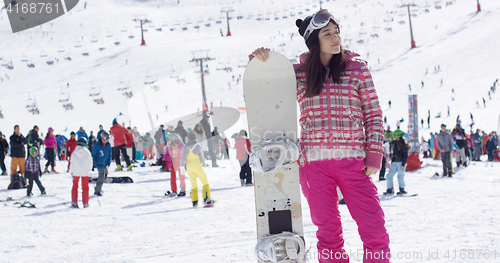 Image of Young woman on ski slope with snowboard