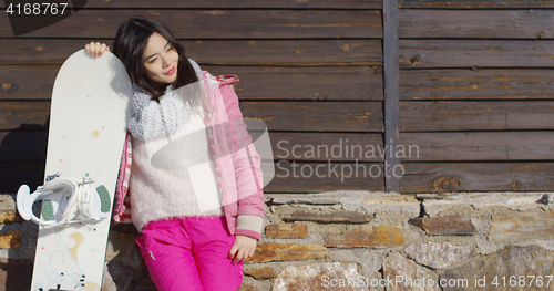 Image of Happy mixed race girl standing with snowboard