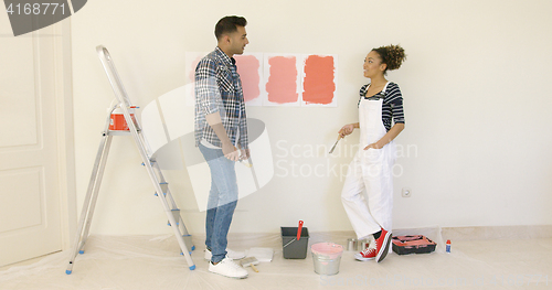 Image of Young couple trying to decide on a paint color