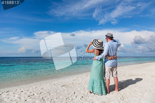 Image of Vacation Couple walking on tropical beach Maldives.