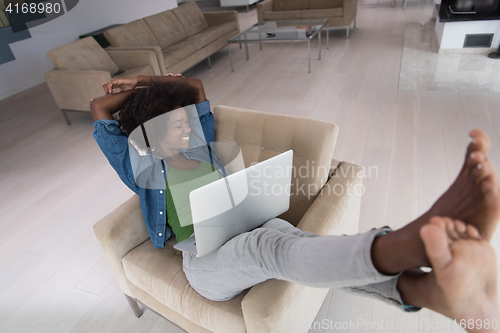 Image of African American women at home in the chair using a laptop