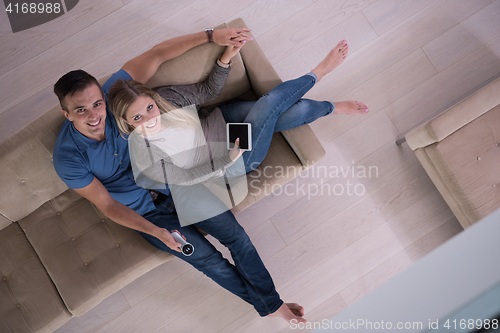 Image of youg couple in living room with tablet top view