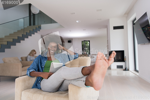 Image of african american woman at home with digital tablet