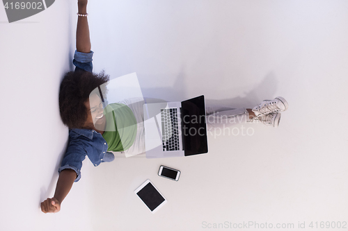 Image of african american woman sitting on floor with laptop top view