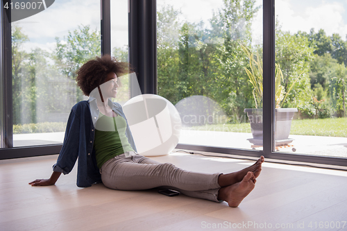 Image of african american  woman  sitting near window