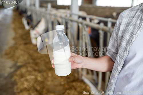 Image of close up of man or farmer with milk on dairy farm