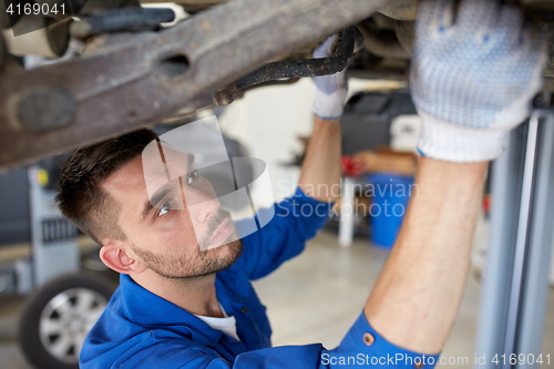 Image of mechanic man or smith repairing car at workshop