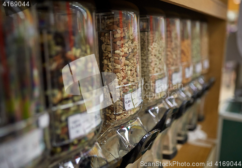 Image of row of jars with nuts and seeds at grocery store