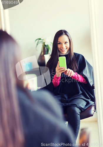 Image of happy young woman at hair salon