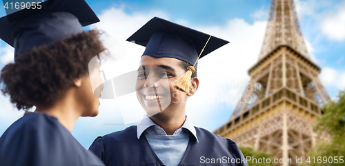 Image of happy students or bachelors over eiffel tower