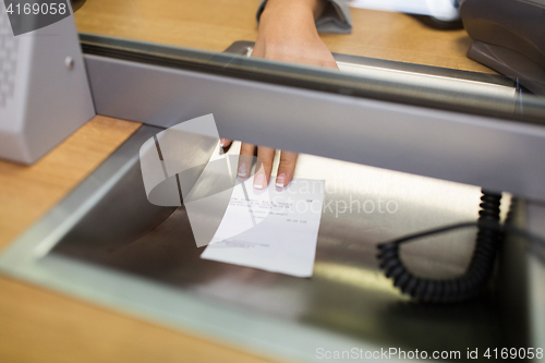 Image of clerk giving receipt at bank or currency exchanger