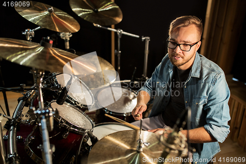 Image of male musician playing drums and cymbals at concert