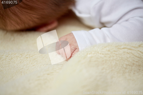 Image of close up of baby lying on soft furry blanket