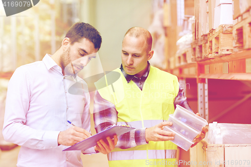 Image of worker and businessmen with clipboard at warehouse