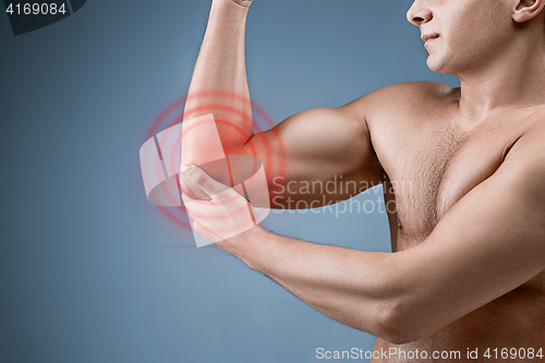 Image of Man With Pain In Elbow. Pain relief concept