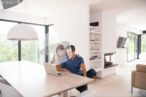 Image of couple using laptop at home