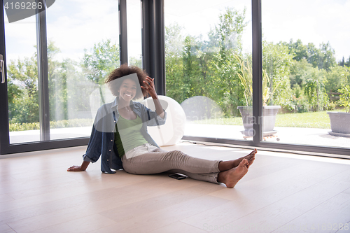 Image of african american  woman  sitting near window