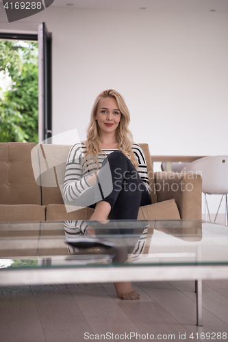 Image of woman sitting on sofa with mobile phone