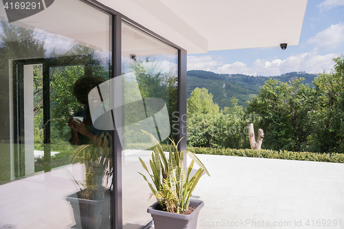 Image of African American woman drinking coffee looking out the window