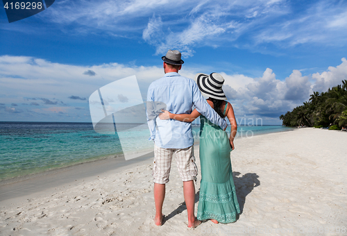 Image of Vacation Couple walking on tropical beach Maldives.