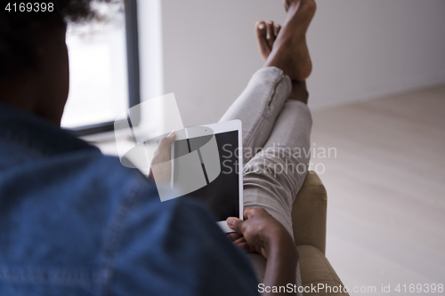 Image of african american woman at home with digital tablet