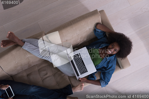 Image of young multiethnic couple relaxes in the living room top view