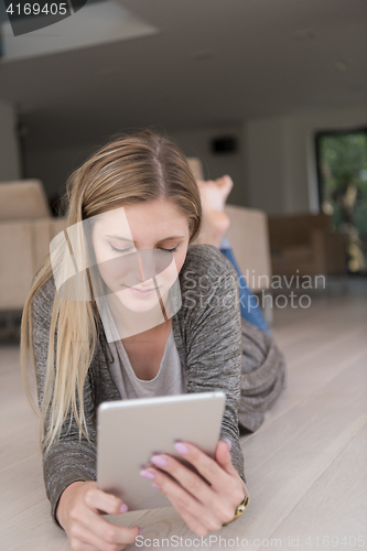 Image of young women used tablet computer on the floor