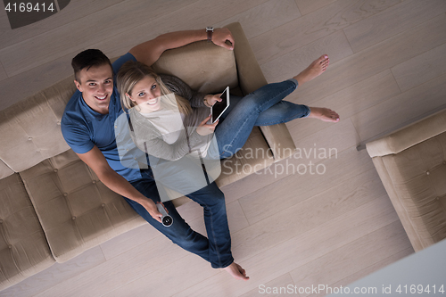 Image of youg couple in living room with tablet top view