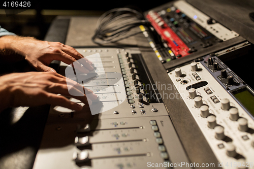 Image of man using mixing console in music recording studio