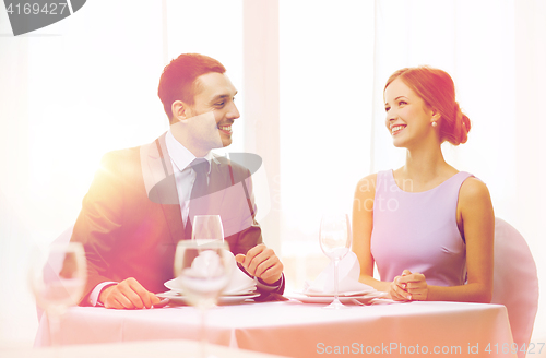 Image of smiling couple looking at each other at restaurant