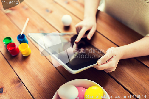 Image of close up of woman with tablet pc and easter eggs