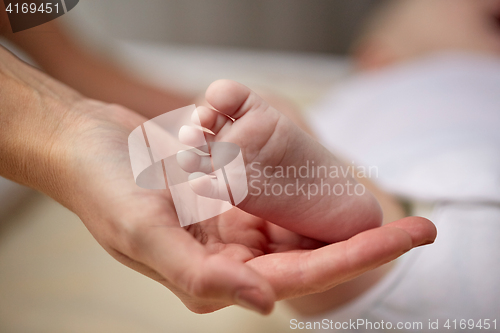 Image of close up of newborn baby foot in mother hand