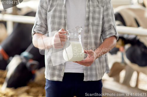 Image of close up of man or farmer with milk on dairy farm